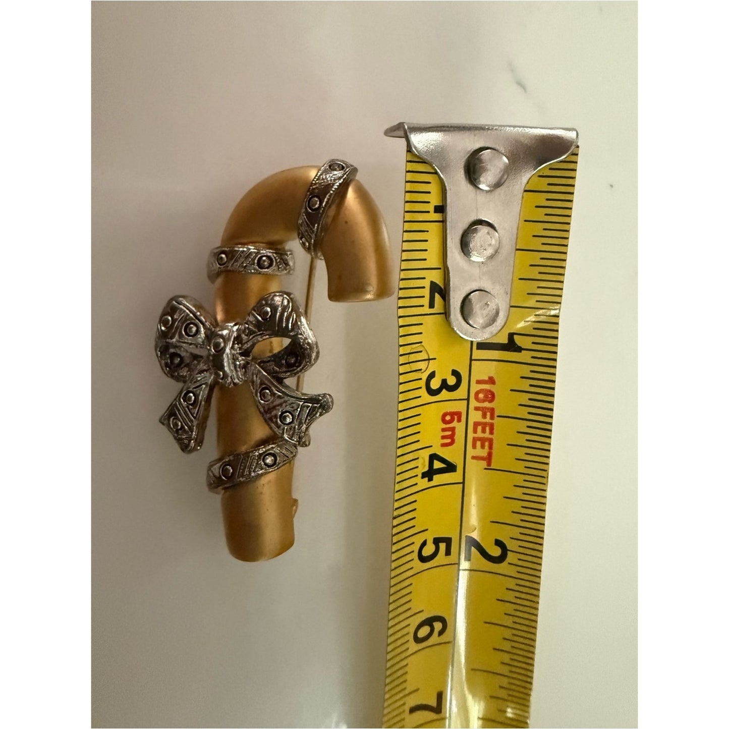 Gold-tone Candy Cane Brooch with Pewter Bow Accent