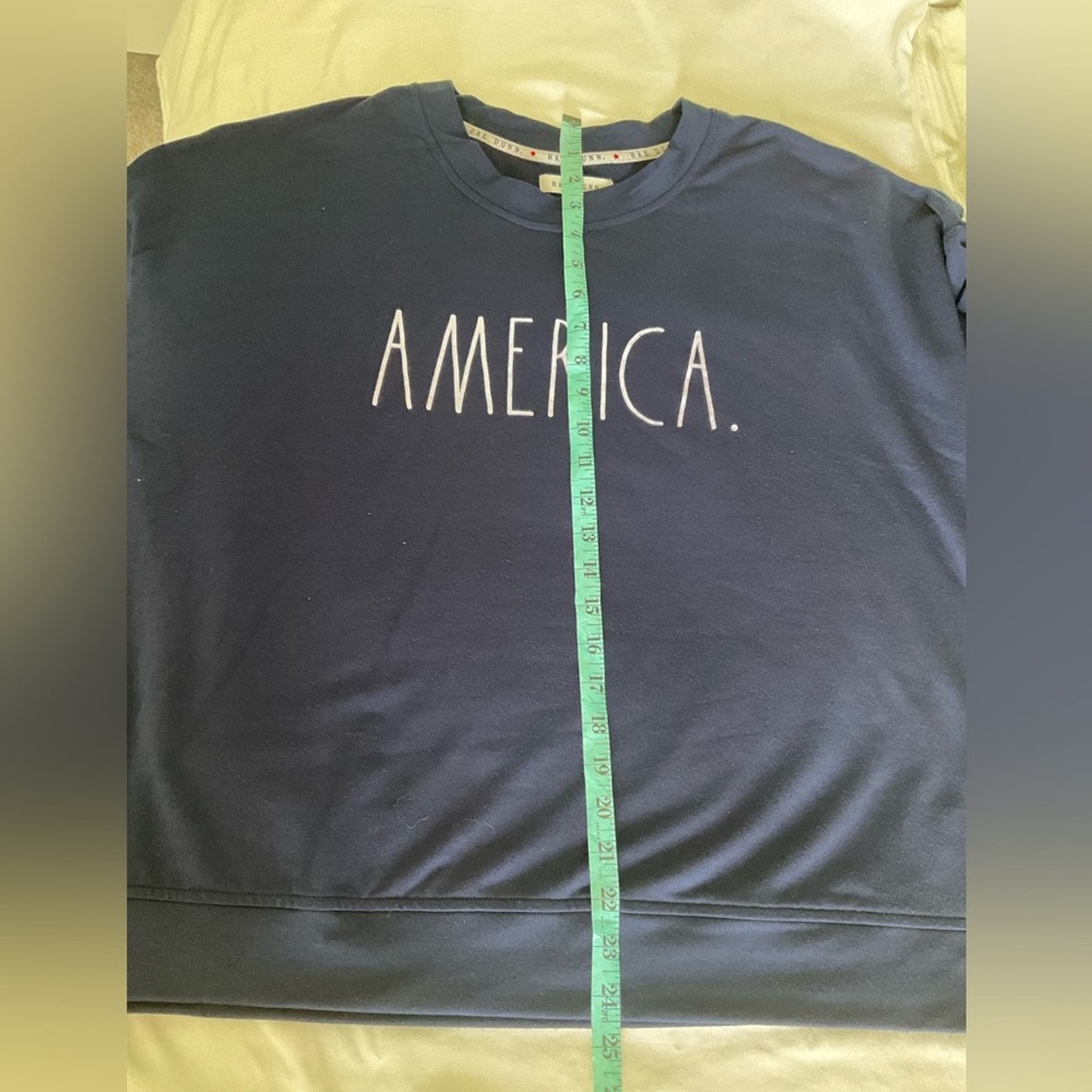 Rae Dunn lightweight sweatshirt in dark blue with word “AMERICA” on front.